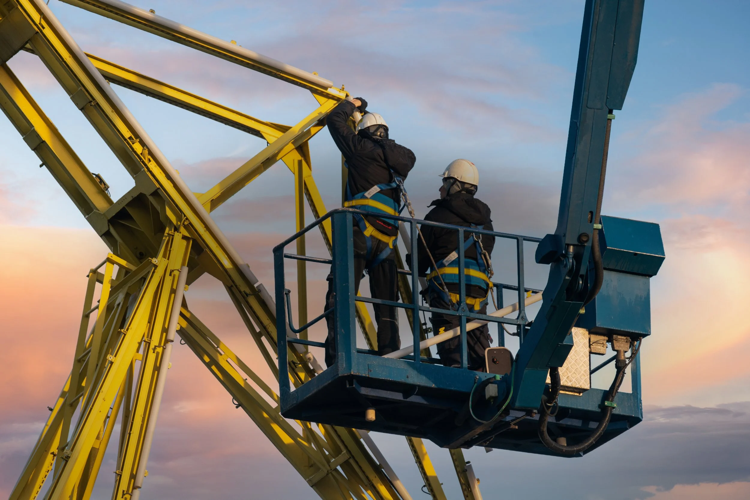 Workers on an elevated platform performing maintenance at height